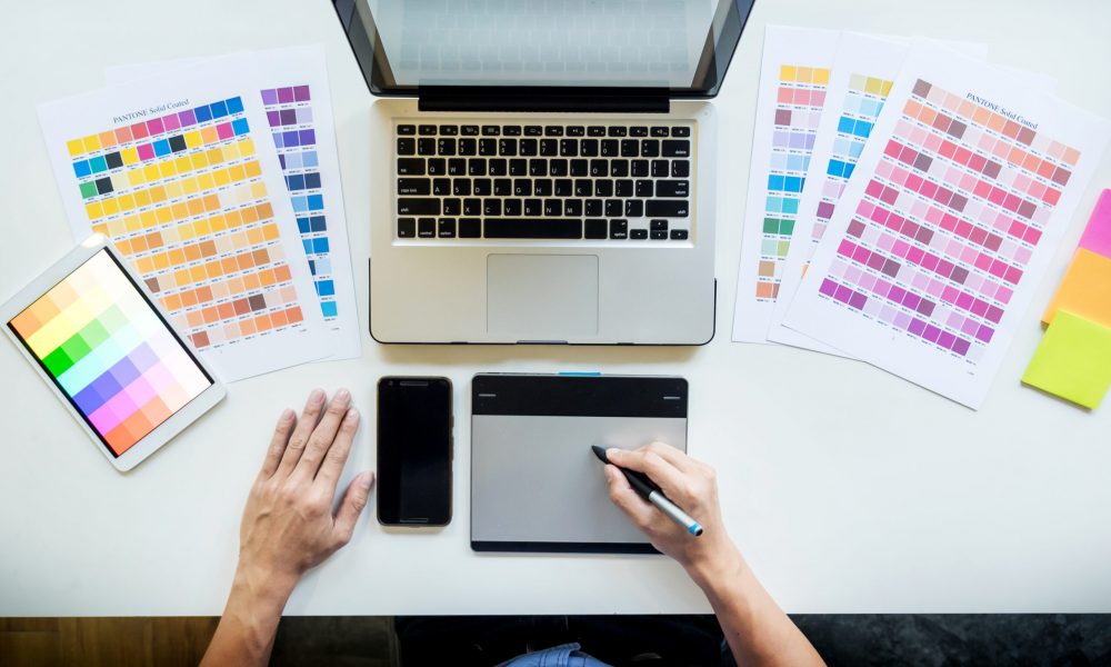 Top view of a young graphic designer working on a desktop comput