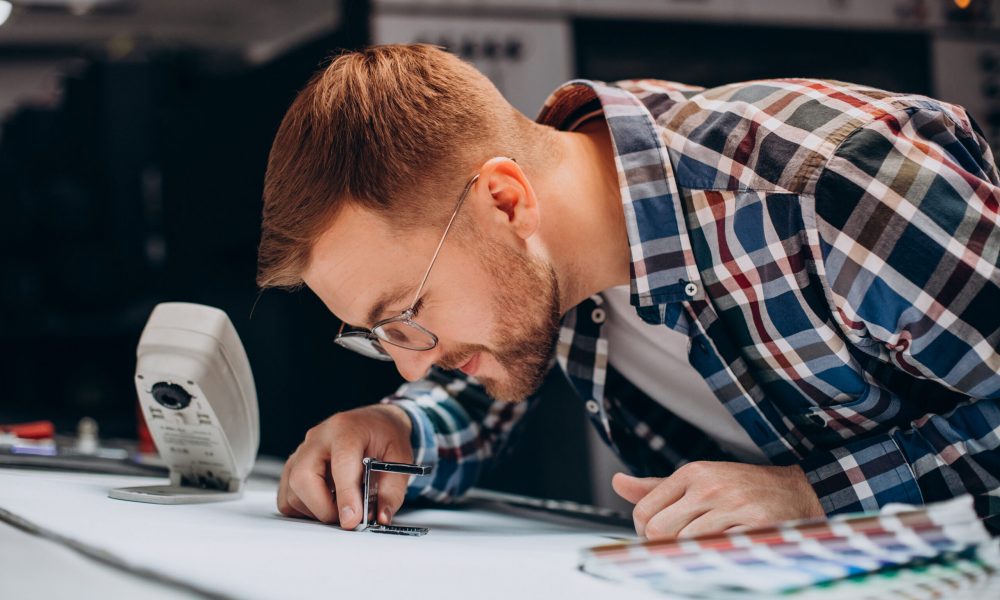 Man working in printing house with paper and paints